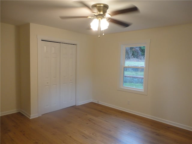 unfurnished bedroom featuring a closet, wood-type flooring, and ceiling fan