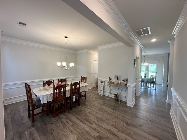 dining area with a notable chandelier, ornate columns, dark hardwood / wood-style floors, and crown molding