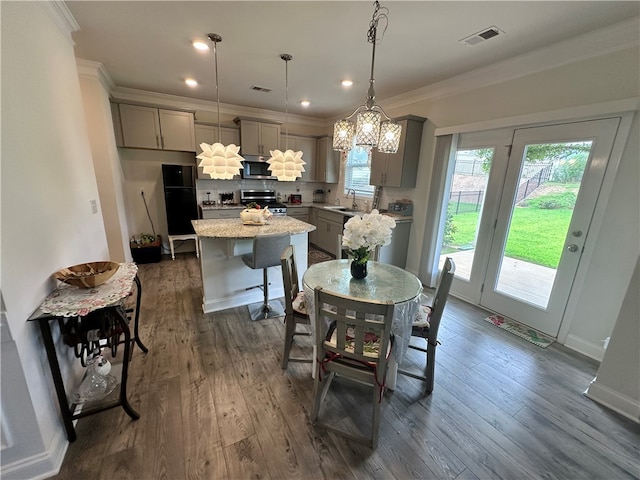 dining space with ornamental molding, dark wood-type flooring, and sink