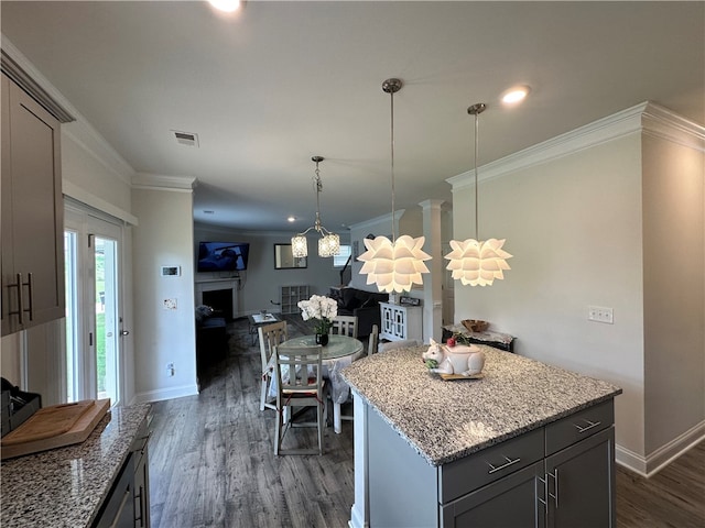 kitchen featuring gray cabinetry, crown molding, dark hardwood / wood-style flooring, and a kitchen island