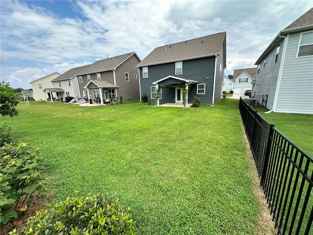 back of house with a patio and a yard