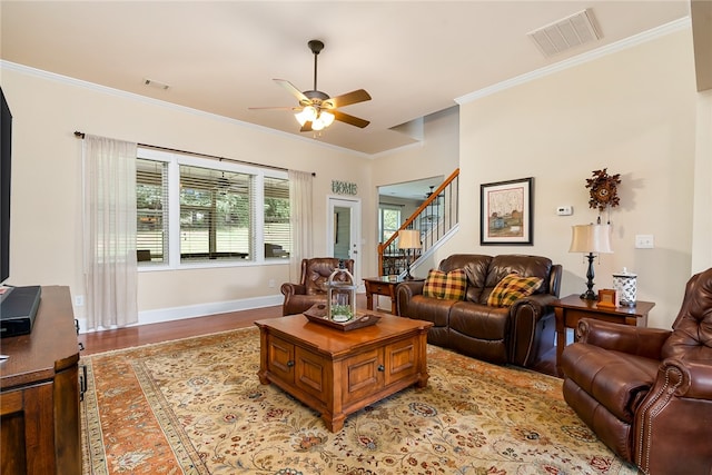 living room with ceiling fan, crown molding, and light hardwood / wood-style floors