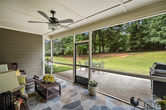 unfurnished sunroom featuring ceiling fan