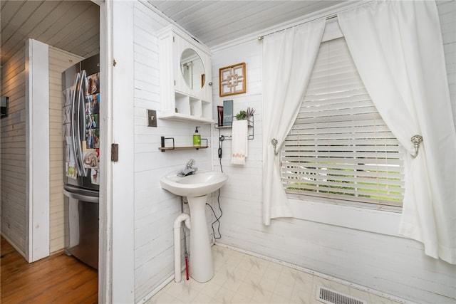 bathroom with wood walls and sink