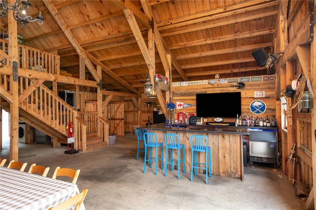 interior space with wood walls, vaulted ceiling, and concrete floors