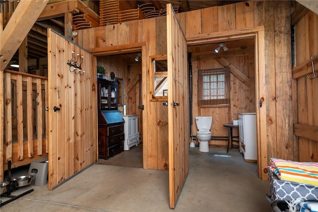 interior space featuring concrete floors and wooden walls