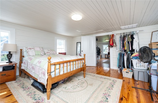 bedroom featuring light wood-type flooring, wood ceiling, and wood walls