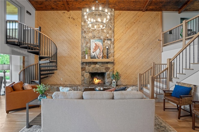 living room with wooden walls, beamed ceiling, a fireplace, and hardwood / wood-style floors