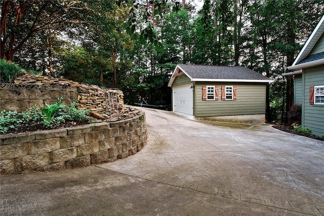 view of patio featuring a garage and an outbuilding