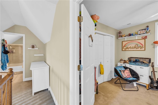 bedroom featuring light carpet, vaulted ceiling, and a closet