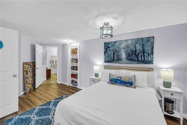 bedroom with a chandelier and dark hardwood / wood-style floors