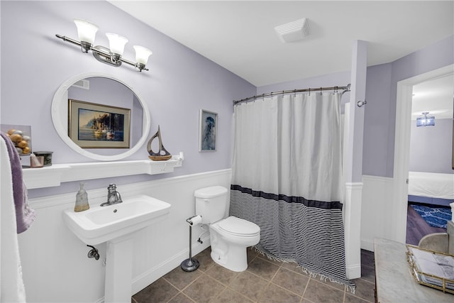 bathroom with walk in shower, tile patterned flooring, and toilet