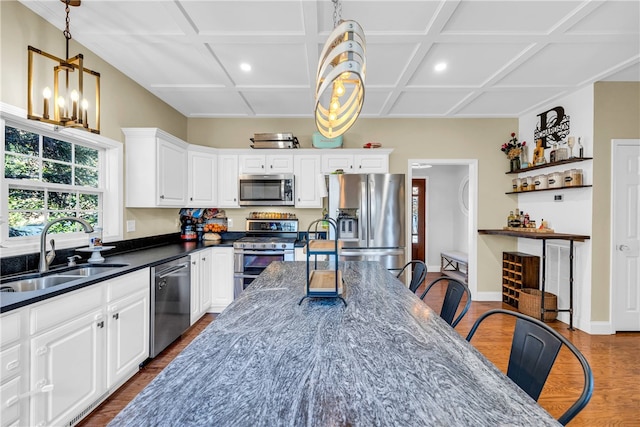 kitchen featuring pendant lighting, stainless steel appliances, white cabinets, and dark hardwood / wood-style floors