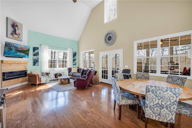 dining area with french doors, hardwood / wood-style floors, and high vaulted ceiling