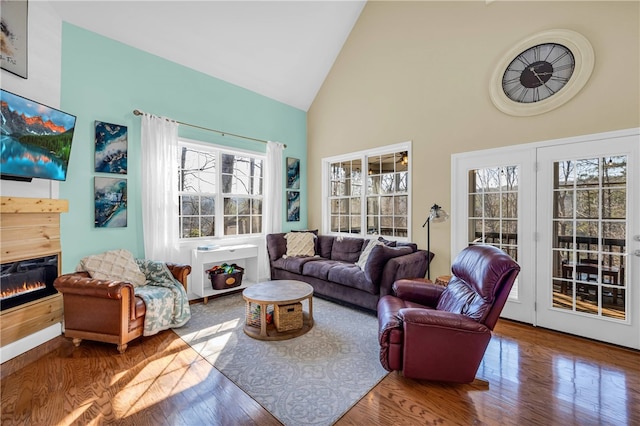 living room with high vaulted ceiling, plenty of natural light, and hardwood / wood-style floors