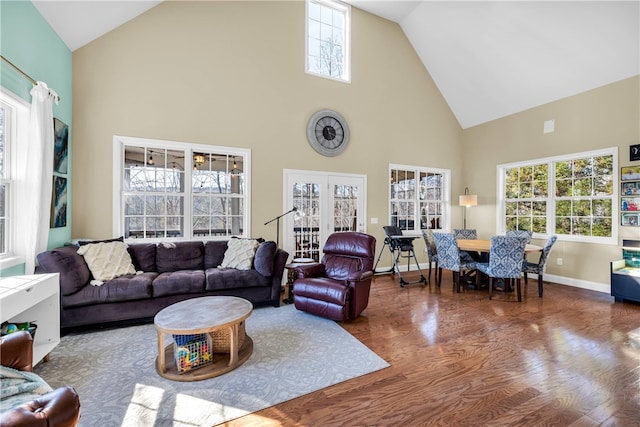 living room featuring high vaulted ceiling, wood-type flooring, and a healthy amount of sunlight