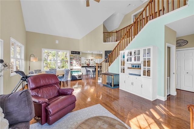 living room featuring hardwood / wood-style floors, ceiling fan, and high vaulted ceiling