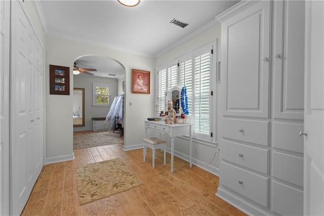 hall with ornamental molding and light hardwood / wood-style flooring