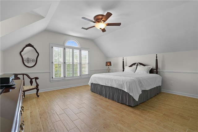 bedroom with ceiling fan, light hardwood / wood-style floors, and vaulted ceiling