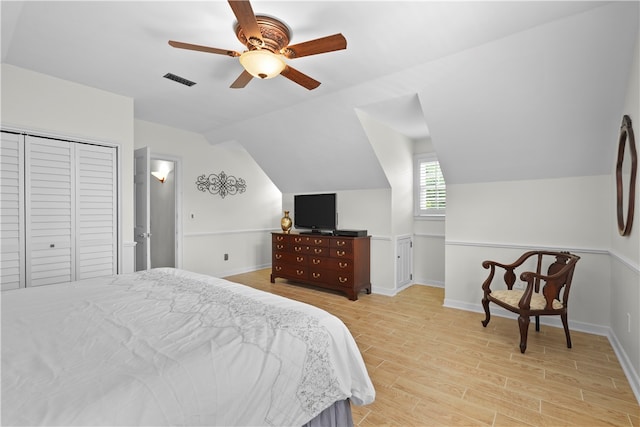 bedroom featuring ceiling fan, light hardwood / wood-style floors, a closet, and vaulted ceiling