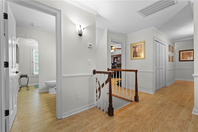 hallway featuring crown molding and light hardwood / wood-style floors