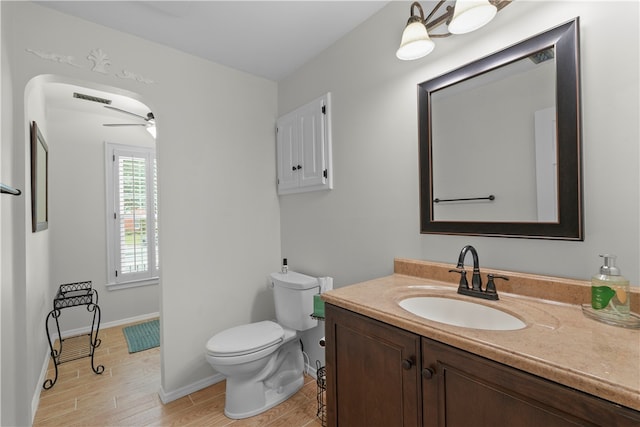 bathroom with ceiling fan, hardwood / wood-style floors, vanity, and toilet