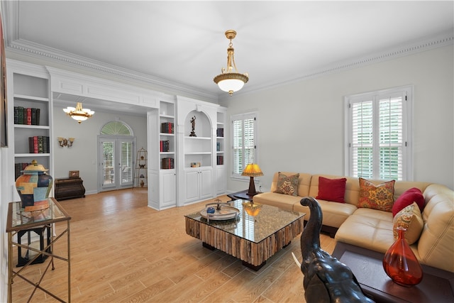 living room with a chandelier, light wood-type flooring, and ornamental molding