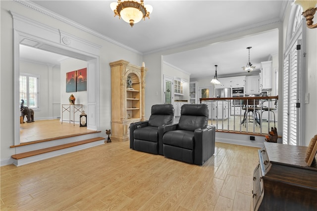 living room featuring an inviting chandelier, ornamental molding, and light hardwood / wood-style flooring