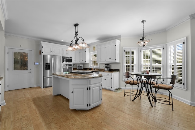 kitchen featuring a center island, crown molding, white cabinetry, and stainless steel appliances