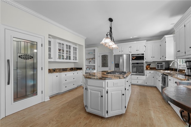 kitchen with white cabinetry, stainless steel appliances, light hardwood / wood-style flooring, crown molding, and a kitchen island