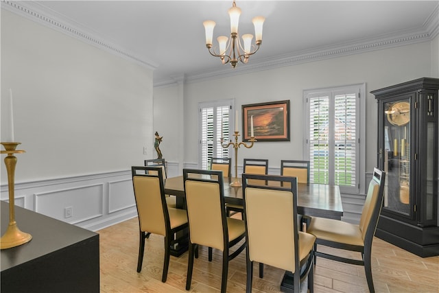 dining area featuring a notable chandelier, ornamental molding, and light hardwood / wood-style flooring