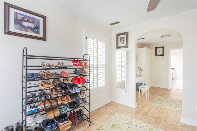 interior space featuring ceiling fan, crown molding, and light hardwood / wood-style flooring