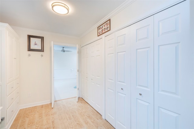 hall with light hardwood / wood-style flooring and ornamental molding