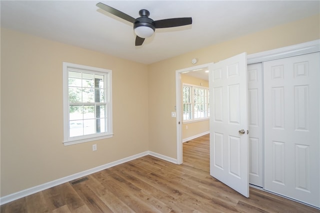 606 N Catherine St, Walhalla, SC 29691 - unfurnished bedroom with multiple windows, a closet, wood finished floors, and a ceiling fan