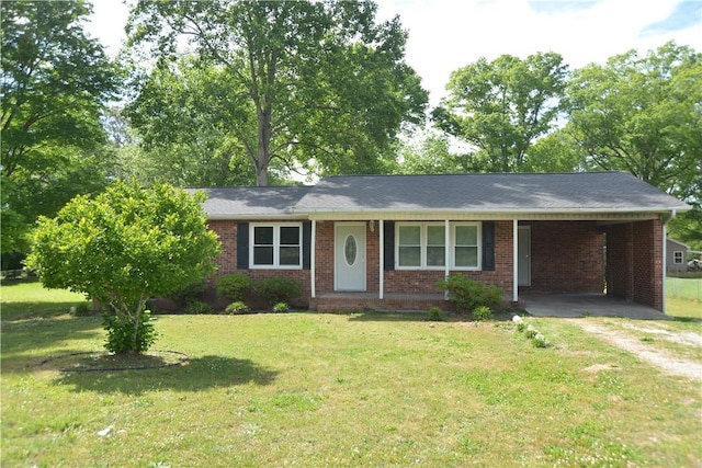 ranch-style home featuring driveway, brick siding, an attached carport, and a front yard
