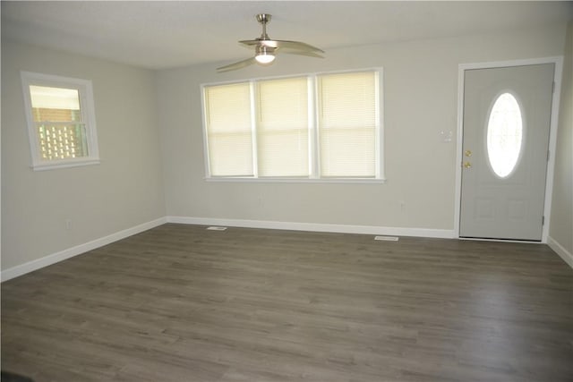foyer entrance with a ceiling fan, baseboards, and dark wood finished floors