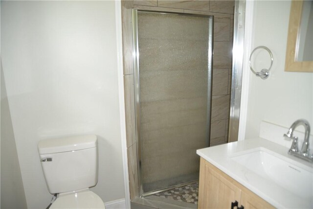 bathroom with vanity, toilet, and a shower with door