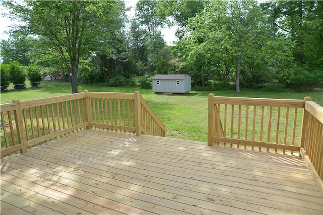 deck with a storage unit, an outbuilding, and a yard