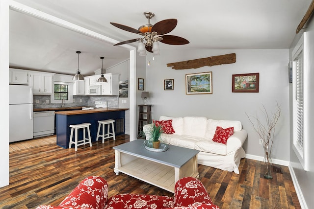 living room with vaulted ceiling, ceiling fan, dark hardwood / wood-style floors, and sink