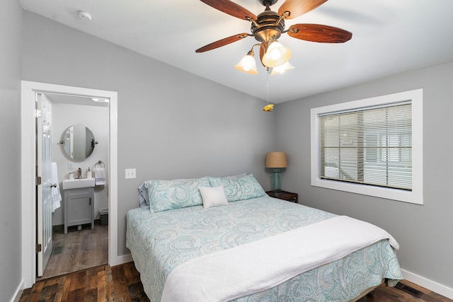 bedroom with dark wood-type flooring, ceiling fan, ensuite bathroom, and sink