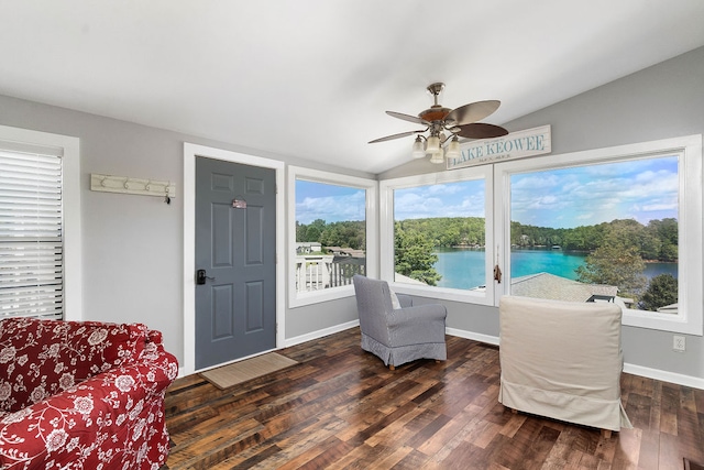 sitting room featuring a water view, lofted ceiling, ceiling fan, and dark wood-type flooring