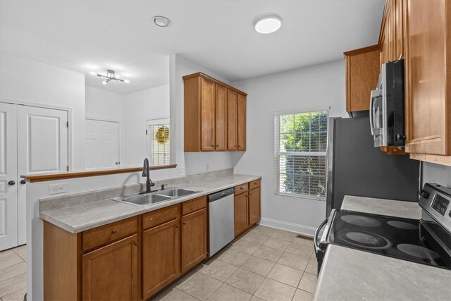 kitchen with sink, light tile patterned floors, and stainless steel appliances