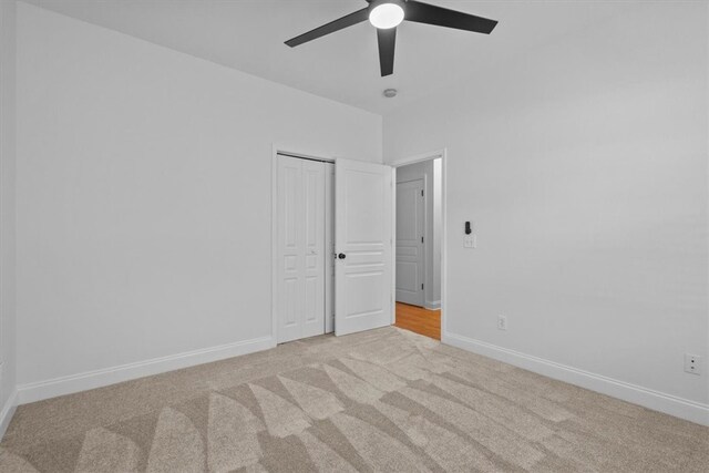 carpeted spare room featuring ceiling fan