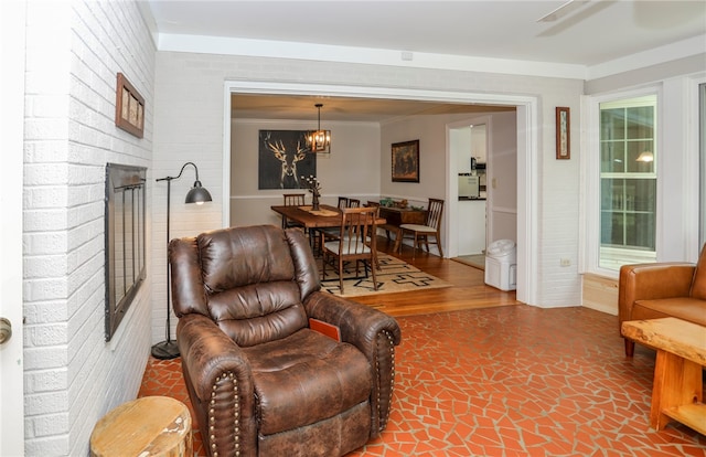 living room featuring a brick fireplace, brick wall, and wood-type flooring