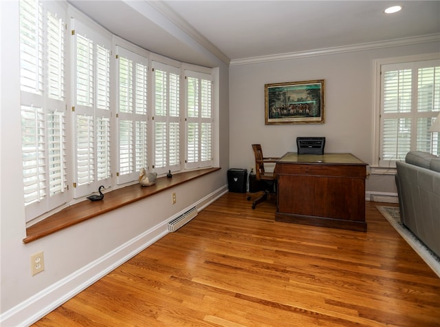 office space featuring a baseboard radiator, light wood-type flooring, ornamental molding, and a wealth of natural light