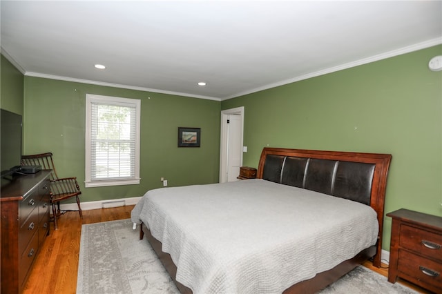 bedroom with wood-type flooring, ornamental molding, and a baseboard heating unit