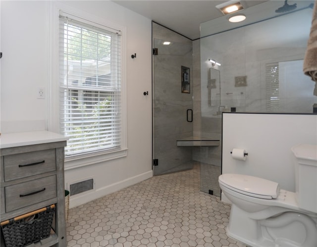 bathroom with vanity, toilet, an enclosed shower, and a wealth of natural light