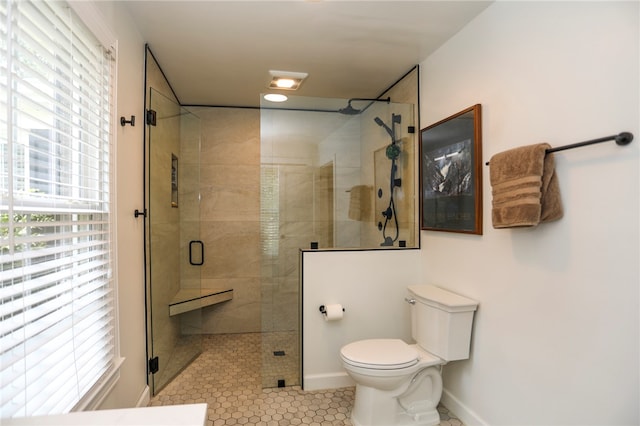 bathroom with tile patterned flooring, a shower with shower door, and toilet