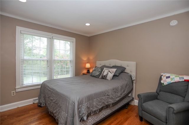 bedroom featuring crown molding, hardwood / wood-style floors, and multiple windows