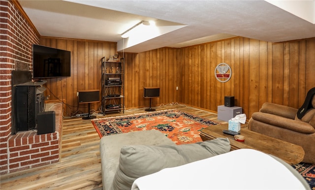 living room featuring crown molding, light hardwood / wood-style floors, and wood walls